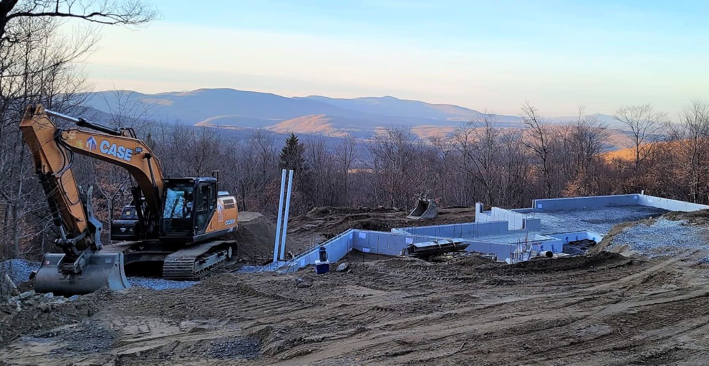 Travaux d’excavation et fondations en Estrie par Les Entreprises Talbot inc – Pelle mécanique CASE en action sur un chantier de construction neuve à flanc de montagne près de Sherbrooke.